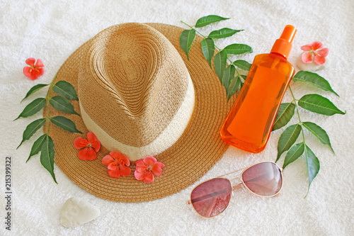 Summer hat with sun glasses and sun oil on white background 