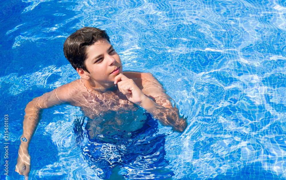Young child on holidays at the swimming pool by the beach serious face thinking about question, very confused idea