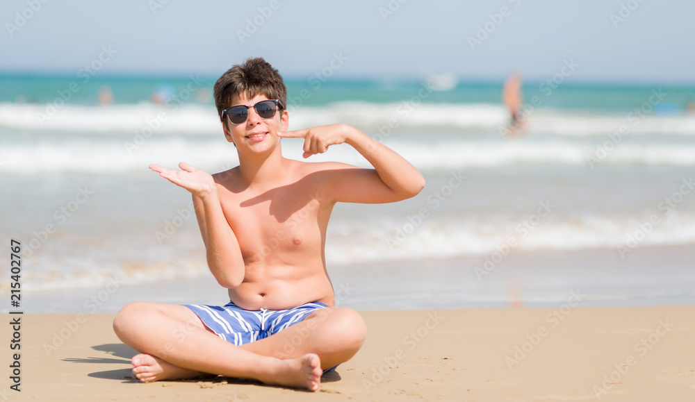 Young child on holidays at the beach very happy pointing with hand and finger Young child on holidays at the beach very happy pointing with hand and finger