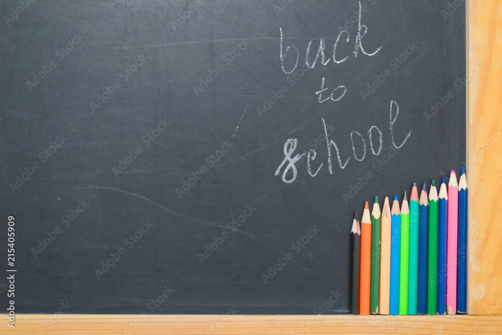Colorful pencils on a black board. School concept Colorful pencils on a black board. School concept