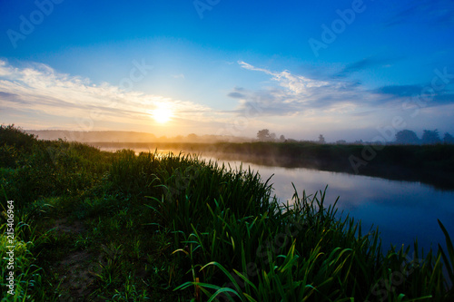 Bright sun shining in blue sky over foggy area