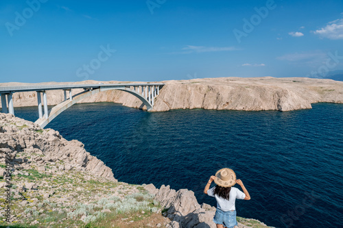 Concept picture of traveling. Woman looking at scenic view by the sea at pag island in Croatia,