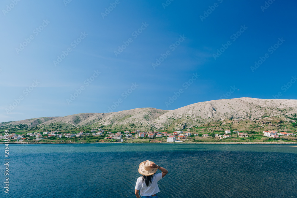 Concept picture of traveling. Woman looking at scenic view by the sea at pag island in Croatia,