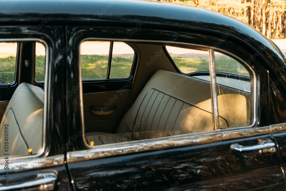 machine black, inside the seat of beige leather, retro car.