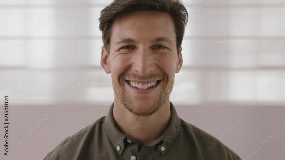 close up portrait of handsome young man smiling happy looking at camera