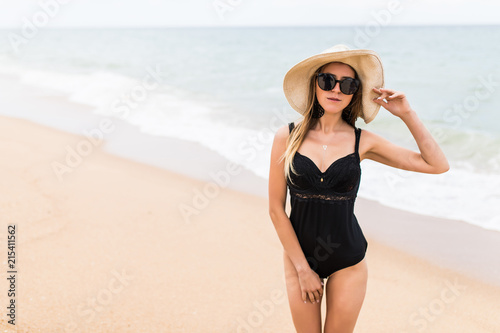 Wallpaper Mural Young pretty Woman in summer vacation wearing straw hat and beach bikini enjoying the view at the ocean Torontodigital.ca