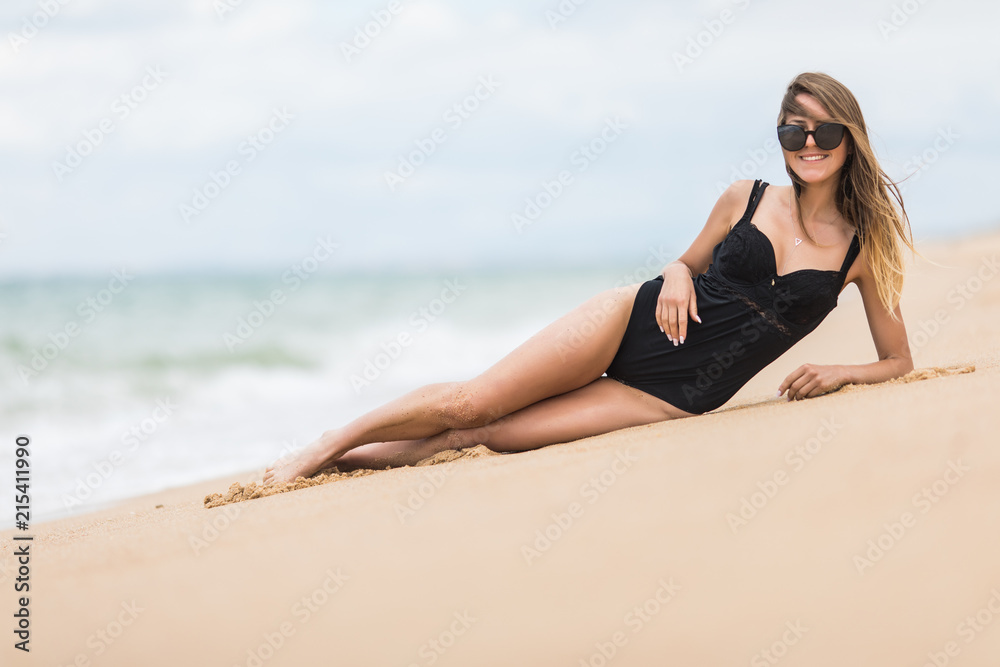 Sexual young girl take sunbath lying on sand on the beach wearing stylish swimwear. Enjoying summer holidays Sexual young girl take sunbath lying on sand on the beach wearing stylish swimwear. Enjoying summer holidays