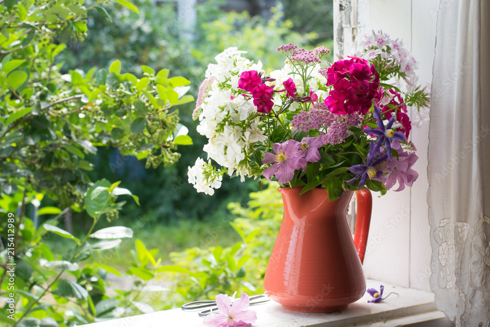 Bouquet of garden flowers on windowsill