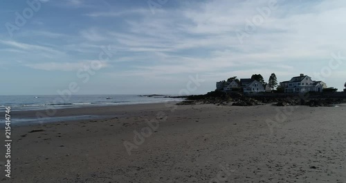 View of the beach at sunset with beautiful homes on the coast.
