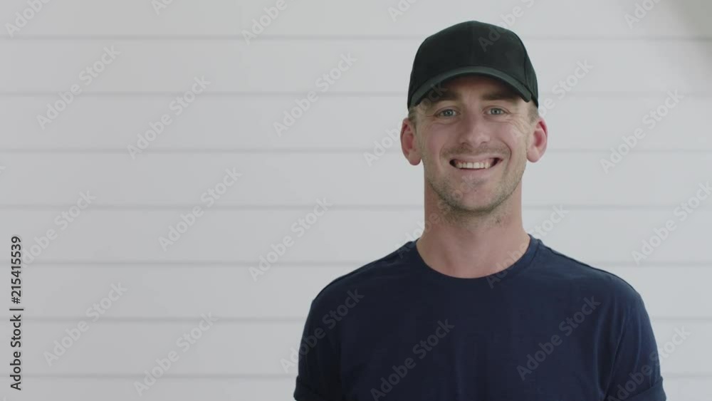 close up portrait of attractive young man smiling happy looking at camera enjoying success wearing hat on white wooden background close up portrait of attractive young man smiling happy looking at camera enjoying success wearing hat on white wooden background