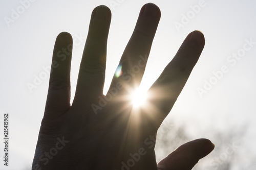 hand close-up, palm sun through fingers, rays