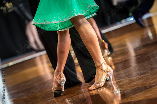 Beautiful womanish and masculine legs in active ballroom dance, indoors photo