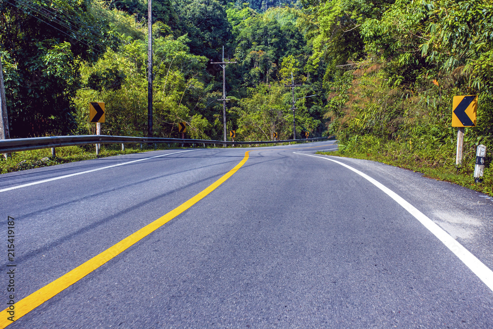 Fototapeta premium Country road in the mountains with forest