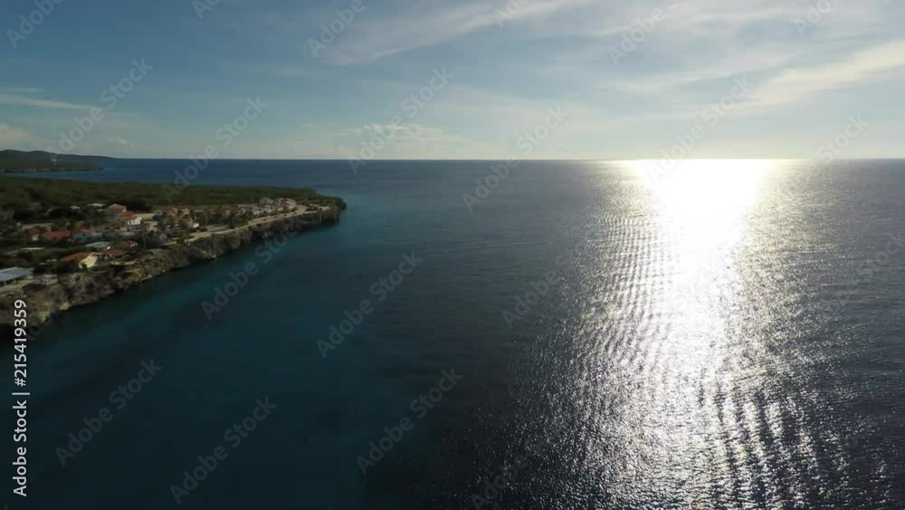 Aerial view of the bright sun and island coast over the ocean. Aerial view of the bright sun and island coast over the ocean.