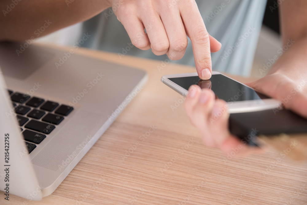 Fototapeta premium Woman texting on a cellphone at a table
