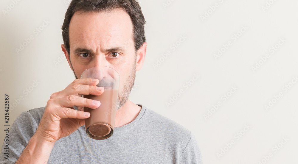 Senior man drinking chocolate milk shake with a confident expression on  smart face thinking serious Photos | Adobe Stock