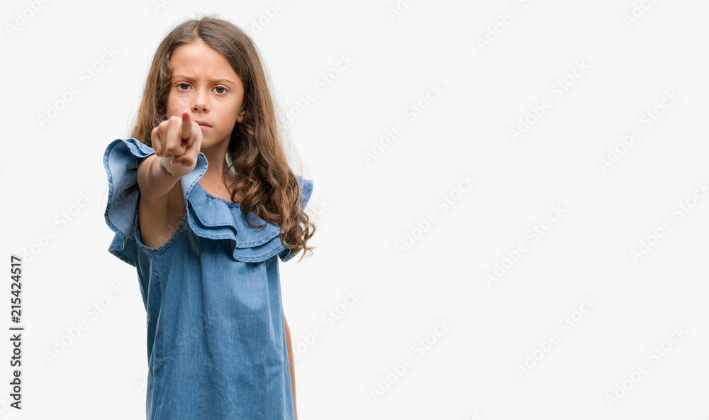 Brunette hispanic girl wearing denim dress pointing with finger to the camera and to you, hand sign, positive and confident gesture from the front Brunette hispanic girl wearing denim dress pointing with finger to the camera and to you, hand sign, positive and confident gesture from the front