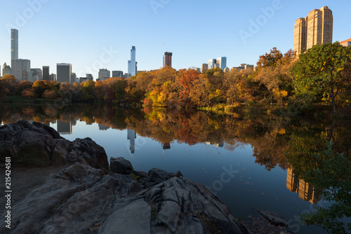 Skyline of Manhattan reflected in a pond in central park at sunrise  New York  United States of America