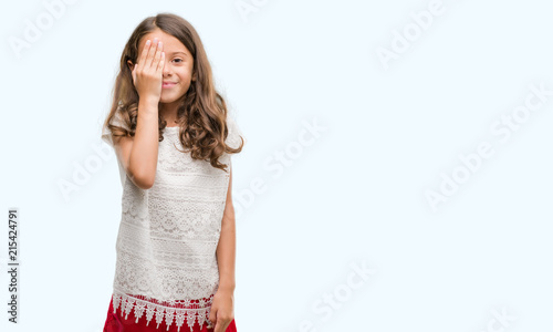 Brunette hispanic girl covering one eye with hand with confident smile on face and surprise emotion. © Krakenimages.com