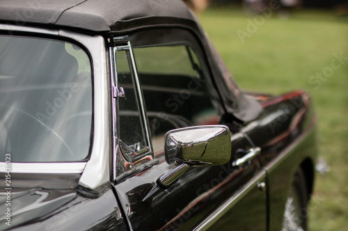 Chrome mirror in an old car. Accessories in cars exhibited at shows. © Piotr