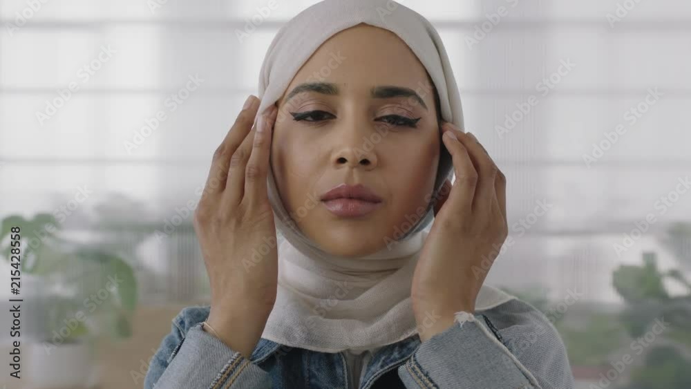 close up portrait of young muslim business woman looking at camera busy preparing headscarf in office workspace background close up portrait of young muslim business woman looking at camera busy preparing headscarf in office workspace background