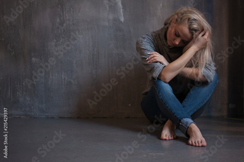 Depressed woman. blonde girl sitting on the floor, sadness and depression © Ulia Koltyrina