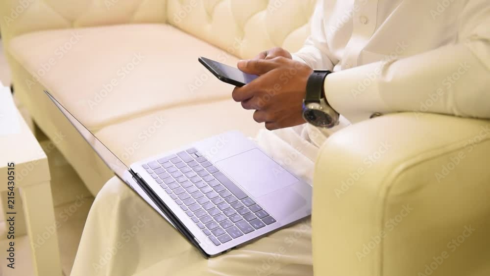 Arabic man working on laptop and smart phone , Saudi businessman , Arab social media working , Arab traditional robe clothing lifestyle Arabic man working on laptop and smart phone , Saudi businessman , Arab social media working , Arab traditional robe clothing lifestyle