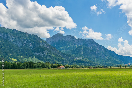Idyllic landscape in the Alps with green meadows and clouds