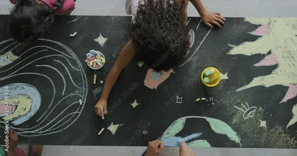multi ethnic children drawing coloring space pictures together on blackboard using chalk happy kids enjoying fun creativity top view