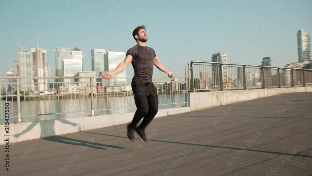 Man skipping at sunrise near Cannery Wharf Man skipping at sunrise near Cannery Wharf