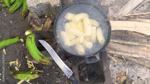 Wallpaper Mural Overhead view of plantains boiling in a pot over an open fire, with a large knife sitting beside the pot. Located in the Dominican Republic. Torontodigital.ca