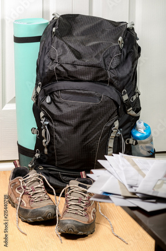 vacation is over (heap of mail on the background of tourist's backpack and shoes by entrance door)