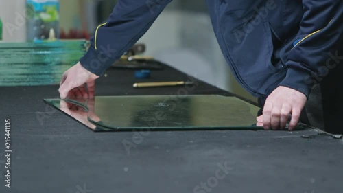 Cutting glass process. Men in gloves cutting glass. Close-up shot