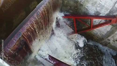 The water runs through the top of a small dam. Slow motion photo