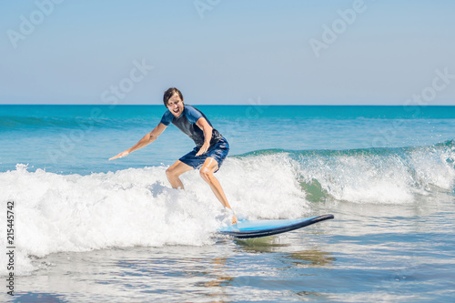 Photography Young man, beginner Surfer learns to surf on a sea foam on the Bali island