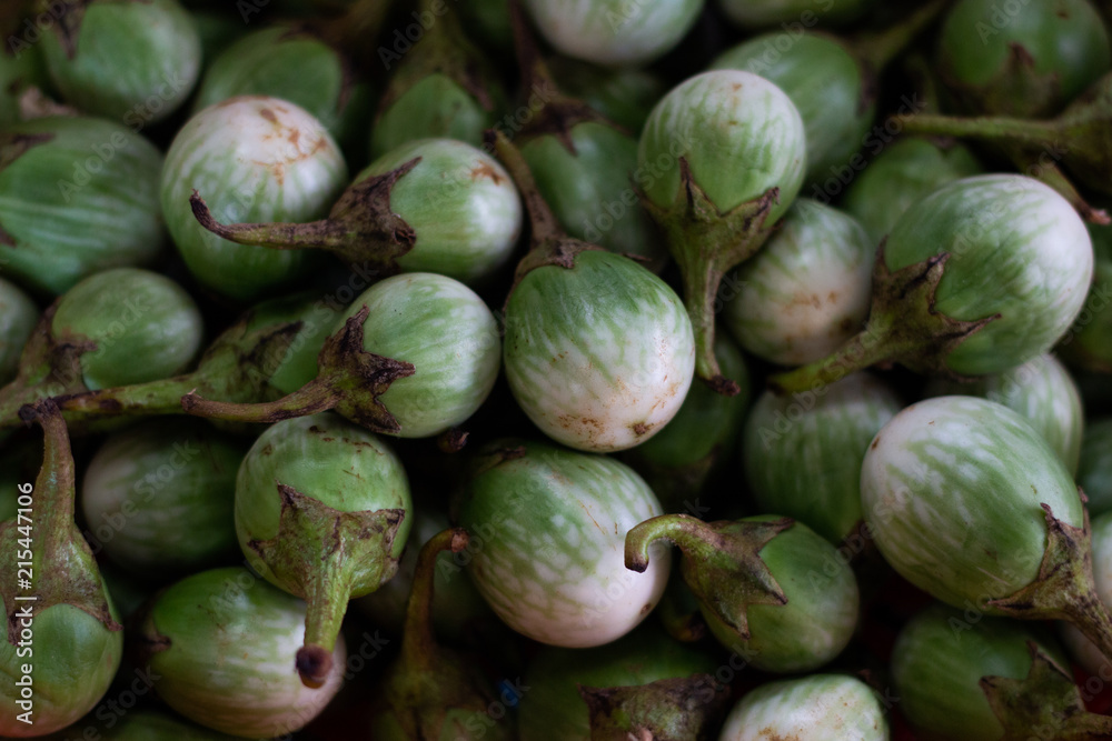 heap of fresh organic eggplants , aubergine balls shaped . vegetable nutrition textured background heap of fresh organic eggplants , aubergine balls shaped . vegetable nutrition textured background