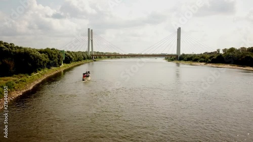 Boat cruising from the city on a big river. Towards bridge photo