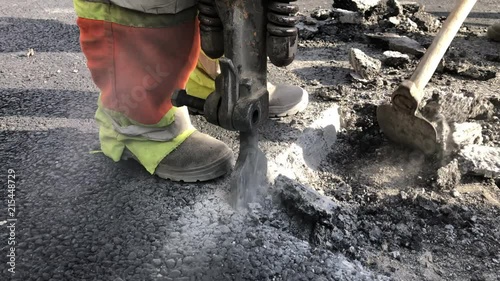 Hackhammer machine destroying asphalt road