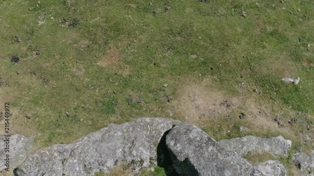Top down aerial tracking forwards over a rocky outcrop with large boulders surrounded by grassy moorland. Dartmoor, England. Top down aerial tracking forwards over a rocky outcrop with large boulders surrounded by grassy moorland. Dartmoor, England.