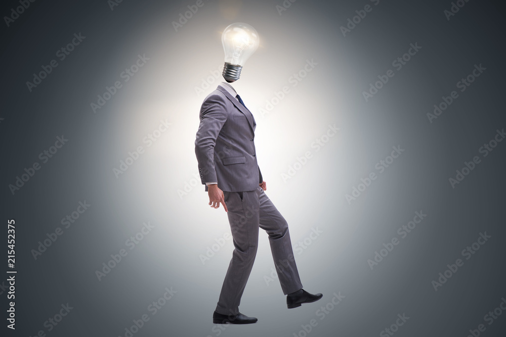 Businessman in bright idea concept with lightbulb head Businessman in bright idea concept with lightbulb head