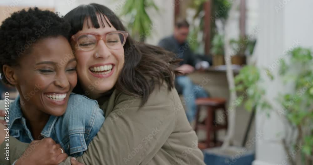 portrait of young woman surprise hugging friend diverse girlfriends embracing laughing enjoying friendship hang out together in urban background portrait of young woman surprise hugging friend diverse girlfriends embracing laughing enjoying friendship hang out together in urban background