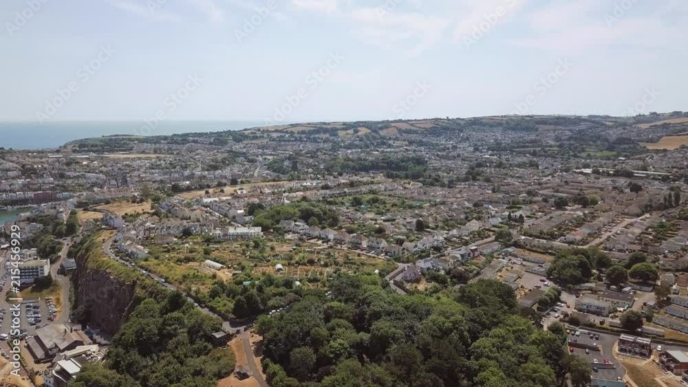 Aerial view of town and coastline in Brixham, England. Sky view of homes, hotels, and resorts in England. Aerial view of town and coastline in Brixham, England. Sky view of homes, hotels, and resorts in England.