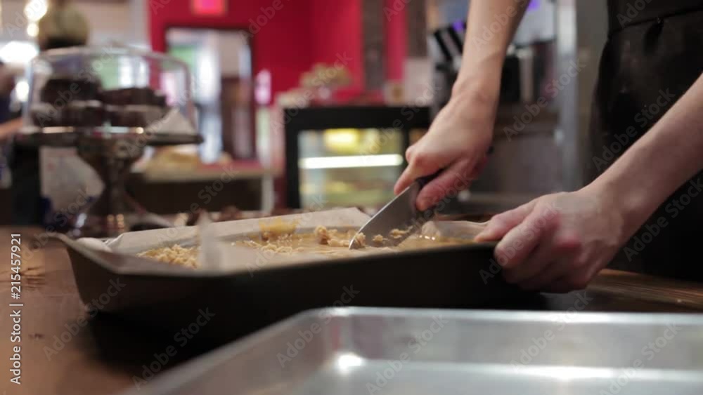 A baker cutting into a cake. A baker cutting into a cake.