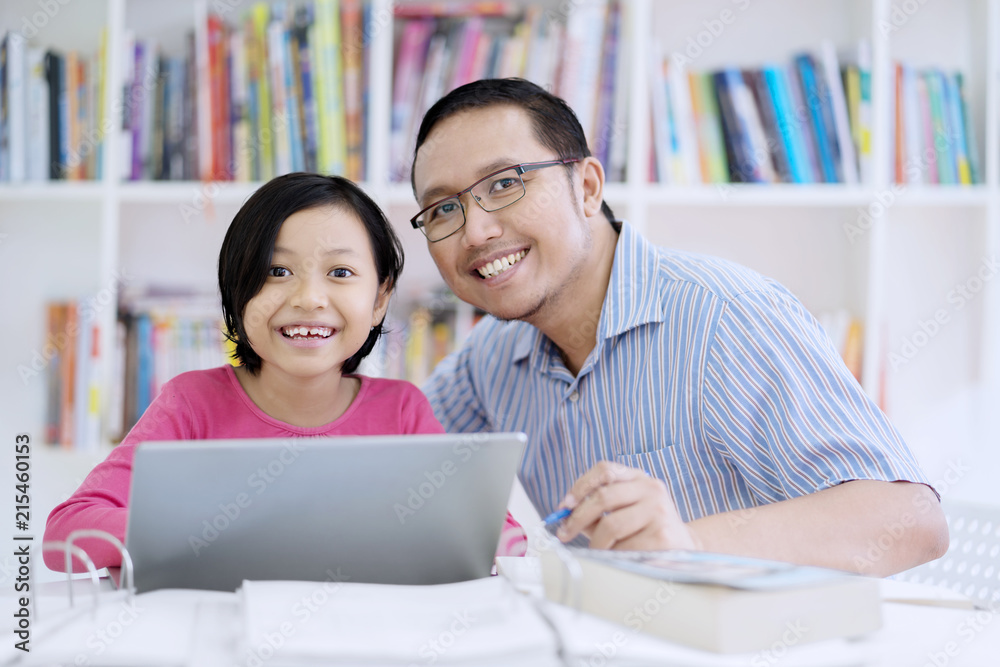 Asian teacher using a laptop with his student Asian teacher using a laptop with his student
