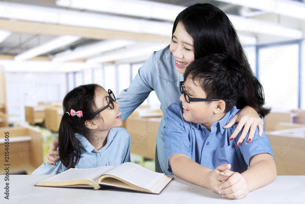 Two students talking with their tutor in class Two students talking with their tutor in class