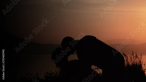Couple kissing in the sunset, passion in contrast with the sunlight photo