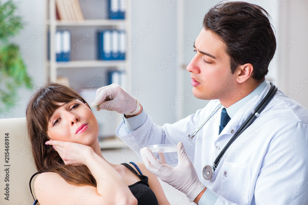 Obraz premium Doctor checking patients ear during medical examination