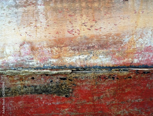 Abstract background of old decaying wooden boat panels painted in red and white