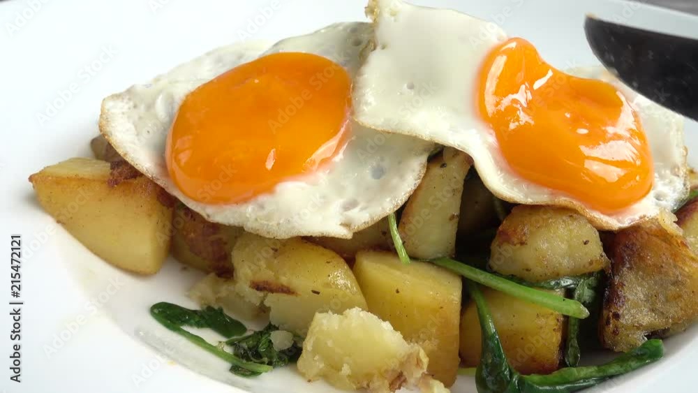 Eating fried eggs with potatoes and spinach. Eating fried eggs with potatoes and spinach.