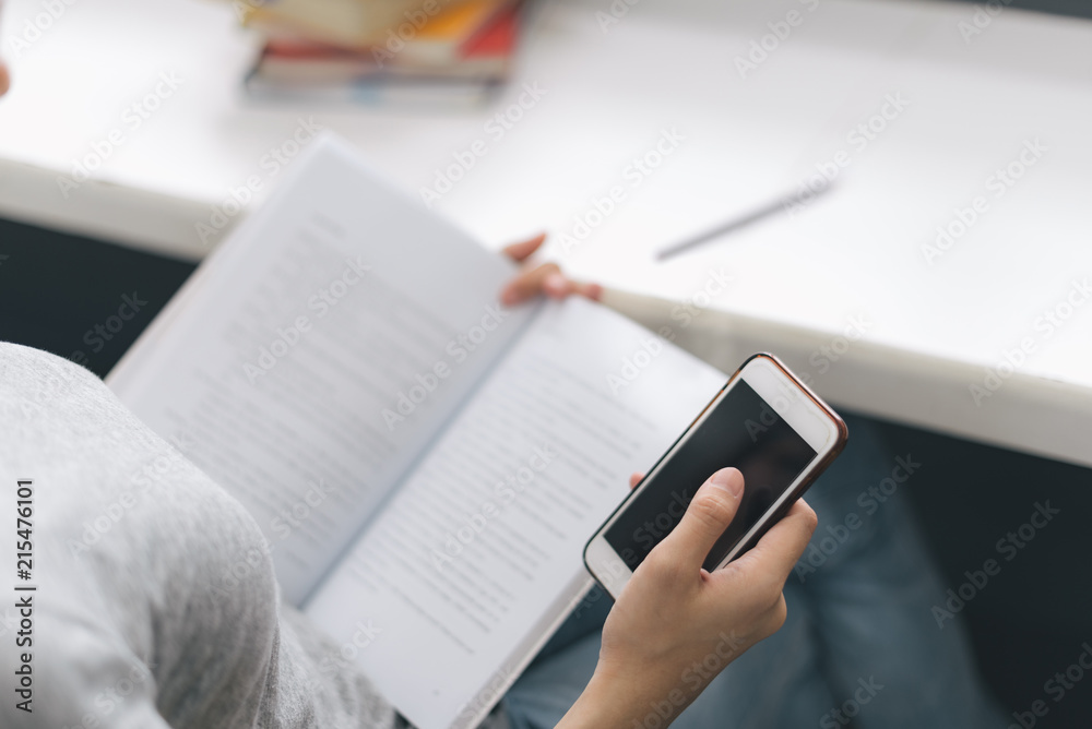 Fototapeta premium Close up Asian woman reading e-book on smartphone in the library..